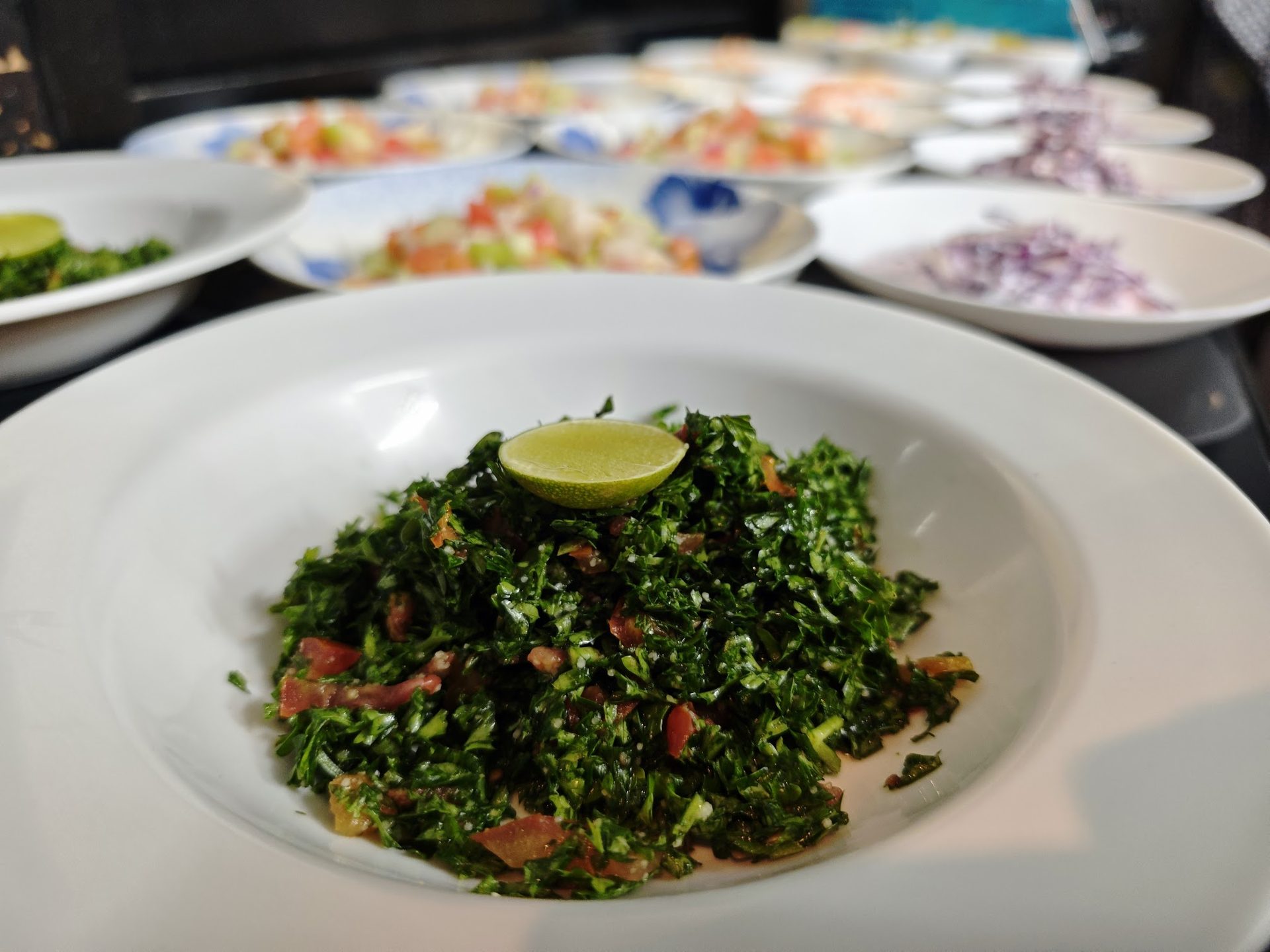 Tabbouleh served with a spread of Middle Eastern salads and appetizers